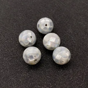 Macro shot of mosaic mother-of-pearl sphere beads with natural iridescent texture for DIY
