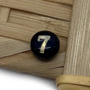 Macro view of a black round bead with golden number 7 for DIY jewelry making
