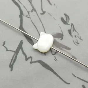 Detailed view of white rabbit-shaped shell bead with natural pearl luster for DIY jewelry