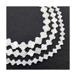 Perles trèfle en nacre blanche naturelle en trois rangs sur un présentoir noir