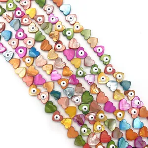 Macro shot of colorful heart-shaped shell beads with evil eye detail for DIY jewelry