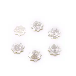 Détail macro de six pendentifs soleil en nacre naturelle avec reflets irisés gravés