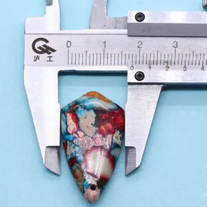 Breedte meten van een kleurrijke natuurstenen hanger met een metalen schuifmaat