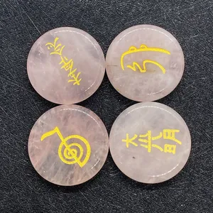 Vista macro de piedras Reiki de cuarzo rosa con símbolos espirituales grabados en oro