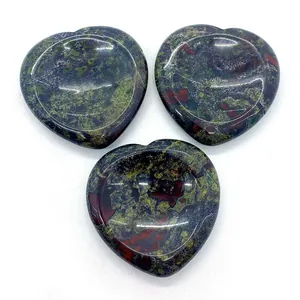 Vue macro de trois gemmes de pierre de sang polies en forme de cœur avec taches rouges