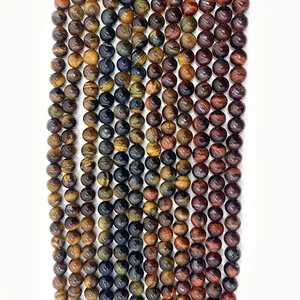 Close-up of polished natural tiger eye beads in yellow, blue and red with cat-eye effect