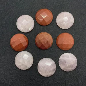 Faceted rose quartz and goldstone round gemstone beads on black textured surface