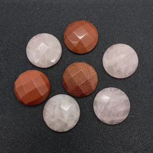 Faceted round rose quartz and gold sandstone gems displayed on a black textured background