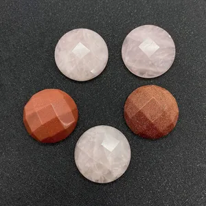 Detailed view of faceted round rose quartz and goldstone gems on a black textured surface