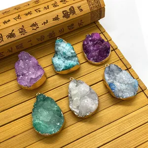Vue macro de pendentifs en grappe de cristal avec bordure dorée sur fond de bambou