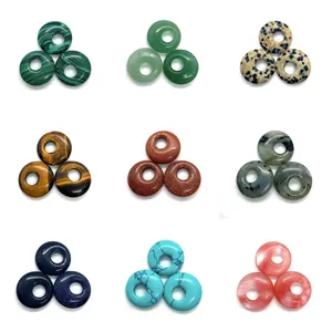 Makro-Detail von neun Naturstein-Donut-Perlen, darunter Tigerauge- und Aventurin-Kristalle