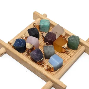 Natural raw stone pendants with gold clasps in rose quartz and lapis lazuli on wood tray