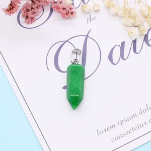 Macro-opname van groene zeshoekige kristallen hanger op cadeaukaart met droogbloemen