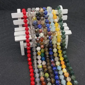 Faceted natural stone beads including agate and lapis lazuli on a white prop display
