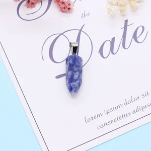 Macro-opname van blauwe sodaliet zeshoekige hanger met zilveren oogje op decoratieve kaart