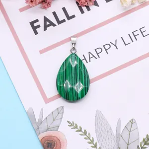 Groene malachiet druppelhanger met zilveren oogje op een elegante roze decoratieve kaart