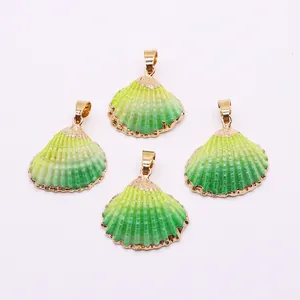Macro detail of natural shell pendants with green gradient glaze and gold plating edges