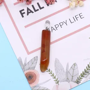 Polished chili-shaped red agate stone pendant with silver clasp on decorative background