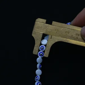 Κοντινό πλάνο από χάντρες ματάκι 8mm που μετρούνται με παχύμετρο ακριβείας