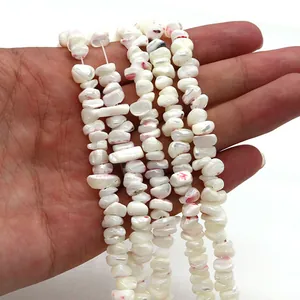 Détail de perles en coquillage naturel avec taches rouges pour la création de bijoux DIY