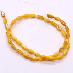 Macro-opname van gele ovale rijstschelpkralen voor DIY sieraden maken accessoires