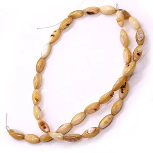 Detailopname van natuurlijke schelpkralen in rijstvorm voor DIY sieraden maken projecten