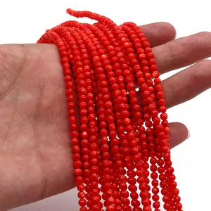 Dettaglio di perle tonde in conchiglia tinta rossa per creazione di gioielli fai-da-te