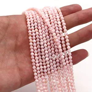 Dettaglio di perline in conchiglia rosa tinte tenute in mano per gioielli fai-da-te