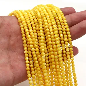 Dettaglio di perline rotonde in conchiglia naturale gialla per creazione di gioielli