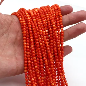Primo piano di perle tonde in conchiglia naturale arancione-rosso per gioielli fai da te
