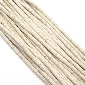 Macro-opname van ivoren Heishi-kralen met gespikkelde textuur voor handgemaakte DIY-sieraden