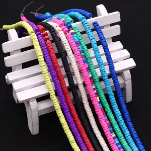 Kleurrijke platte kleikralen voor DIY sieraden aan een witte decoratieve bank