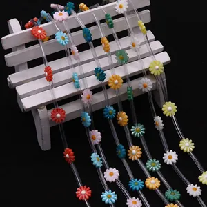 Colorful freshwater shell daisy flower beads for DIY jewelry making on white bench