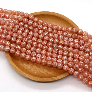 Macro di perle a mosaico in conchiglia arancio-rosa su un vassoio di legno naturale