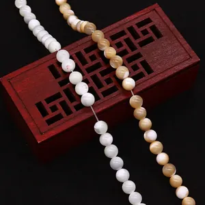 Natural seashell round beads for DIY jewelry making displayed on a vintage jewelry box