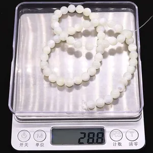 Natural white shell beads on a digital scale weighing 28.8 grams for DIY jewelry