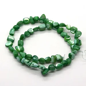 Gros plan de perles de nacre vertes irrégulières avec un éclat naturel pour bijoux DIY