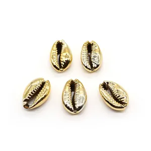 Detailansicht von fünf metallisch goldenen Kauri-Muschelperlen für DIY-Schmuck und Ketten