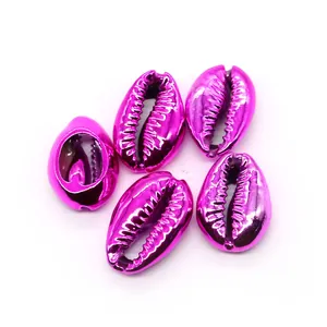 Close-up of five metallic magenta electroplated cowrie shells for DIY jewelry making