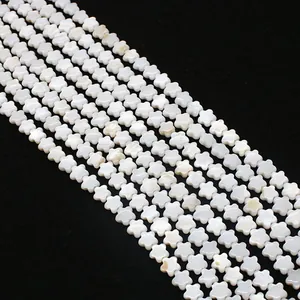 Macro-detail van witte bloemvormige parelmoer kralen voor het maken van sieraden
