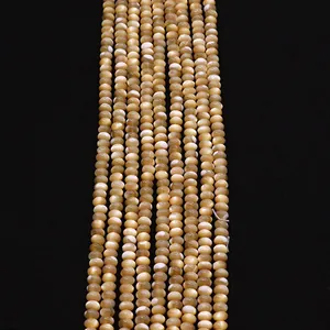 Macro view of golden natural shell beads with pearlescent finish for DIY jewelry making