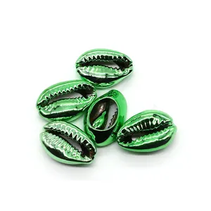 Macro view of five green metallic electroplated cowrie shells for DIY jewelry making