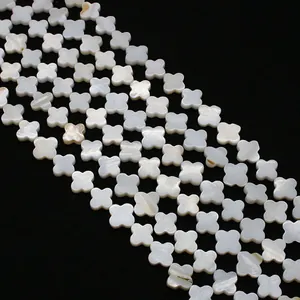Detailed close-up of natural white mother of pearl clover shaped loose beads on black backdrop