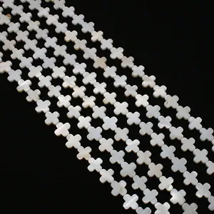 Macro view of white mother of pearl cross beads strands on black background