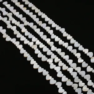 Close-up of heart-shaped natural freshwater shell beads with white iridescent luster