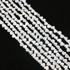 Macro-opname van witte hartvormige natuurlijke schelpkralen met iriserende glans voor DIY