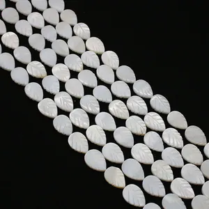 Macro shot of white leaf-shaped mother of pearl beads with natural iridescent shell luster