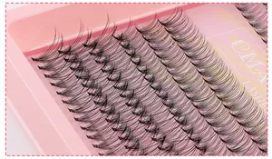 Macro close-up van individuele cluster wimper extensions in een roze tray met D-krul