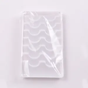 Detailed view of white plastic 6-row eyelash organizer tray with curved slots