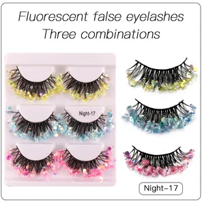 Detailed view of dense neon false eyelashes with golden, blue, and pink glitter sequins